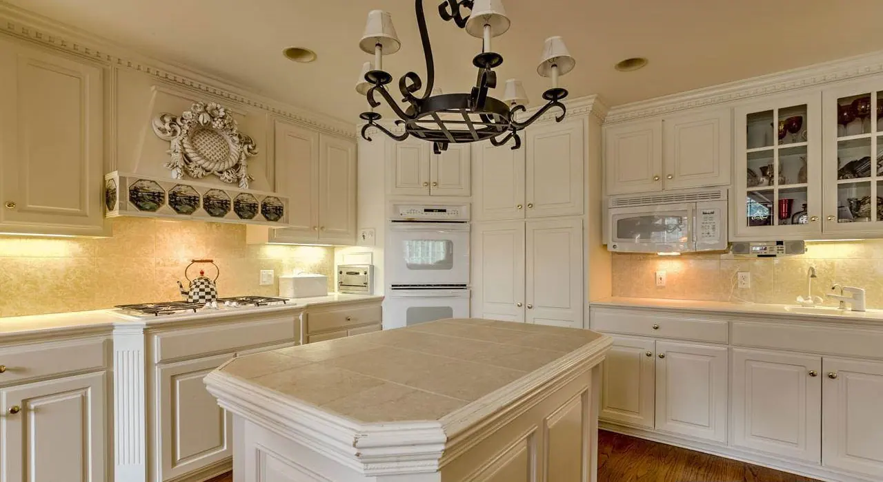 Kitchen with white painted cabinets and a center island, finished by The Painting Company